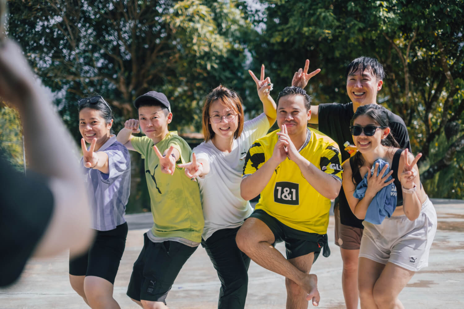 Puma team leaders making fun poses for a group photo during an outdoor team building activity at Hillcrest Dawn