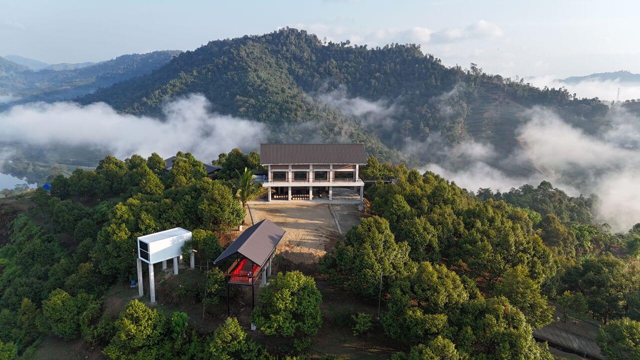 Aerial view of Skycrest Dawn villa on a misty hilltop in Bentong, Pahang, ideal for corporate team building retreats.