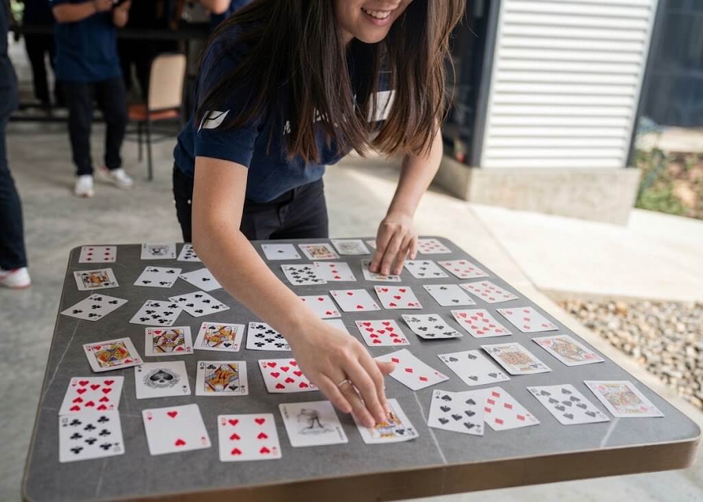 Raigo Group team member playing the Da Vinci Code card game during a corporate team building retreat at a villa.